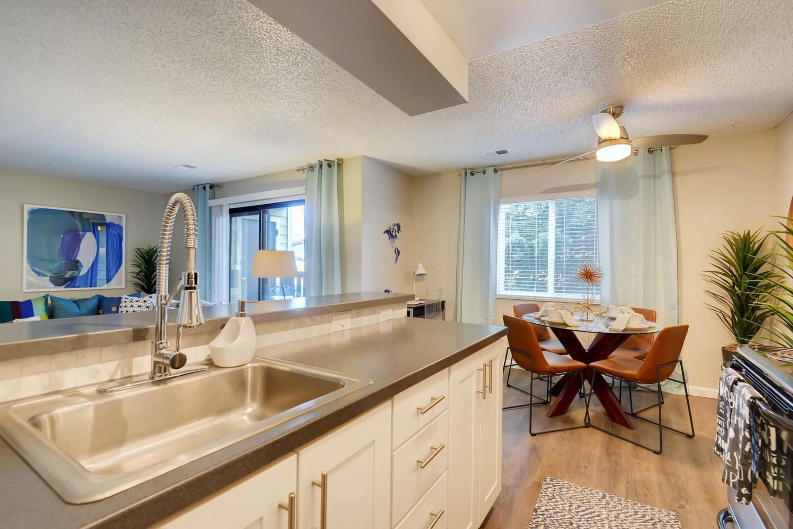 Kitchen with stainless steel appliances and tile backsplash, view of dining area