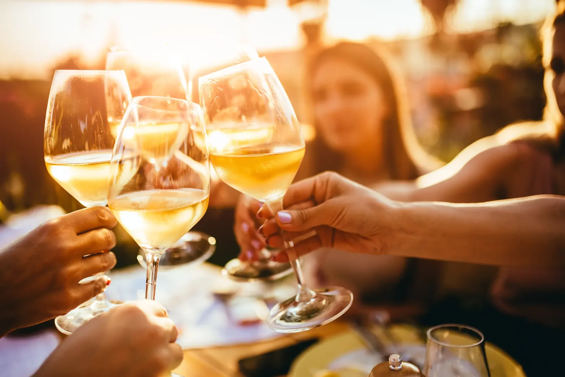 Friends at an outdoor event clinking glasses together for a toast