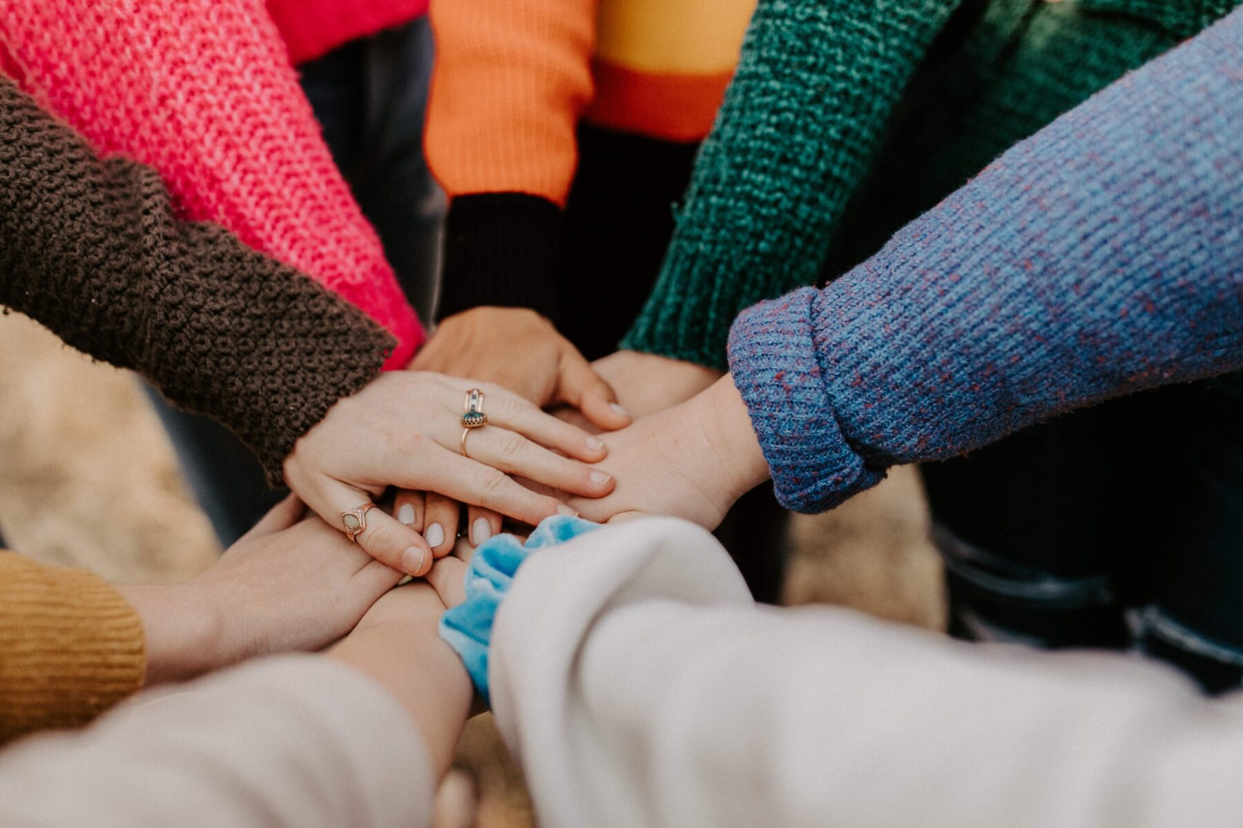 people placing their hands together in a circle as a sign of teamwork