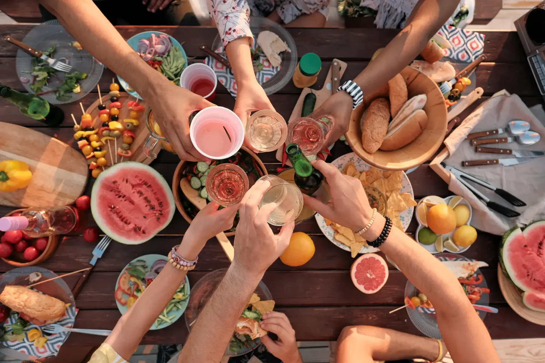 Group of people sitting around table with food and drinks